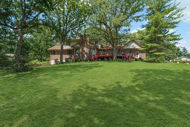 an aerial view of a house with garden space and trees all around