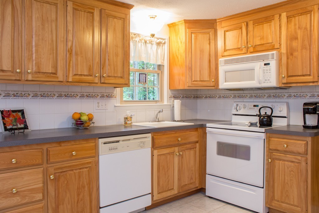 25 Green Valley Road Medway, MA 02053 - Photo 16 of 30 a kitchen with stainless steel appliances granite countertop a sink a stove and cabinets