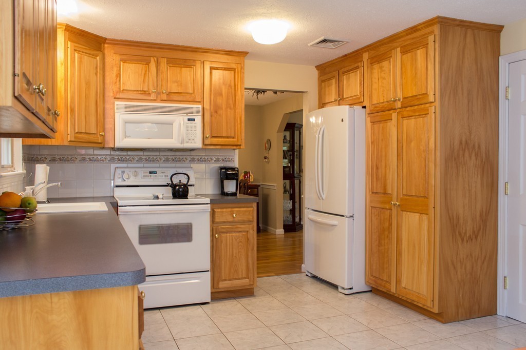 25 Green Valley Road Medway, MA 02053 - Photo 18 of 30 a kitchen with a refrigerator a sink and cabinets