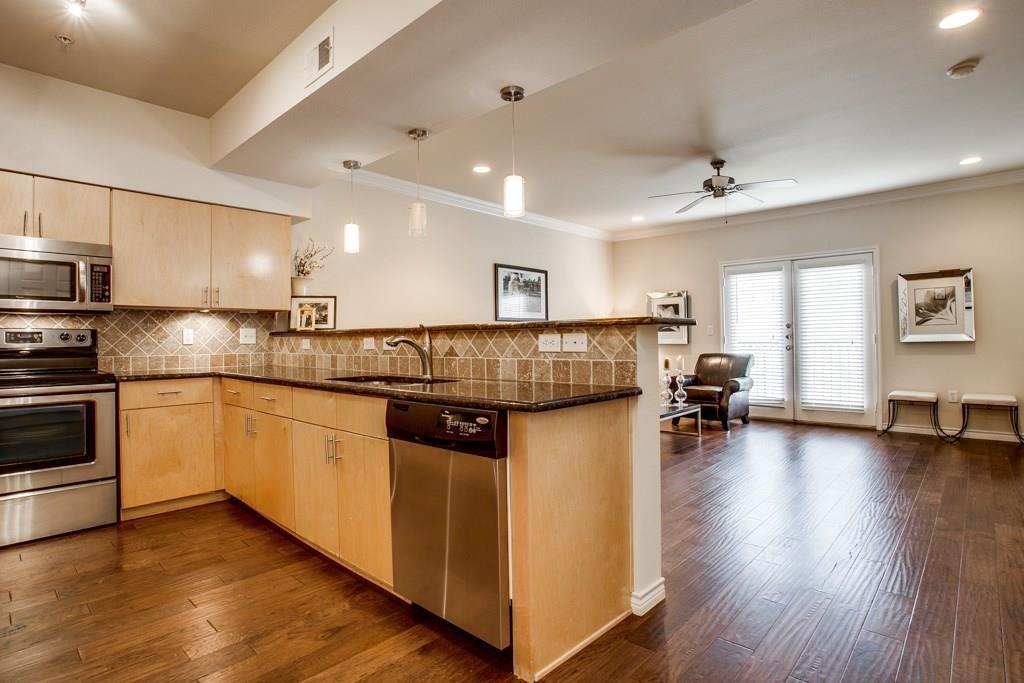 3102 Kings Road, Unit 3310 Dallas, TX 75219 - Photo 4 of 19 a kitchen with kitchen island granite countertop wooden floors and white stainless steel appliances