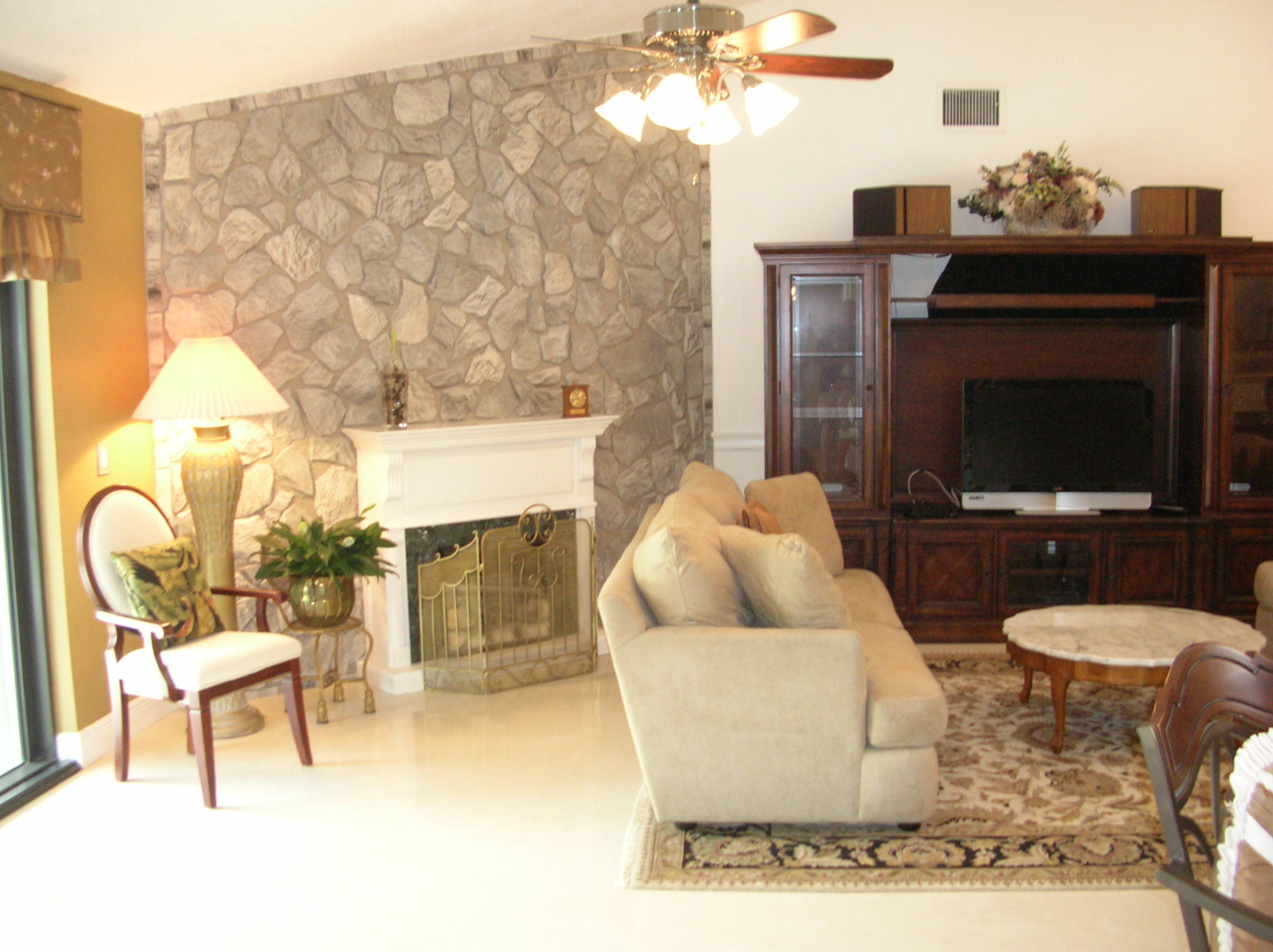 228 Northwest 69th Street Boca Raton, FL 33487 - Photo 12 of 31 a living room with furniture a flat screen tv and a fireplace