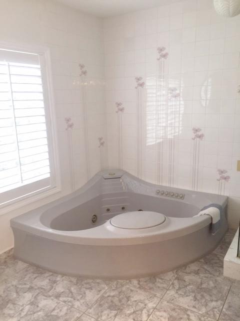 228 Northwest 69th Street Boca Raton, FL 33487 - Photo 18 of 31 a white bath tub sitting in a bathroom next to a window