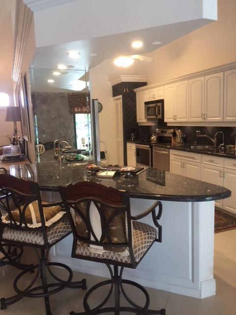 228 Northwest 69th Street Boca Raton, FL 33487 - Photo 8 of 31 a kitchen with a table chairs sink and cabinets