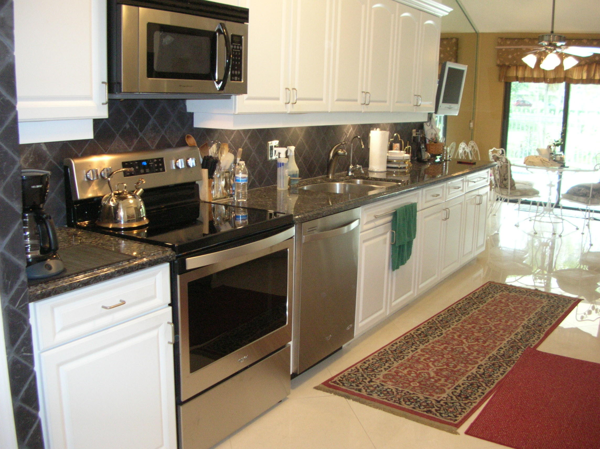 228 Northwest 69th Street Boca Raton, FL 33487 - Photo 10 of 31 a kitchen with stainless steel appliances granite countertop a stove a sink and a microwave