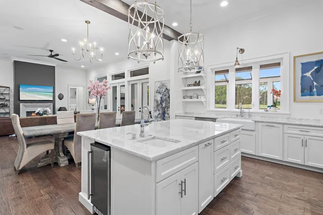 a hall with kitchen island a sink stove a dining table and chairs