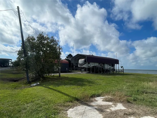 a view of a big house with a big yard and a large tree