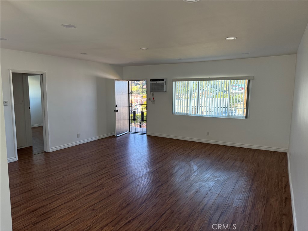 7159 Greeley Street, Unit F Tujunga, CA 91042 - Photo 13 of 15 an empty room with wooden floor and windows