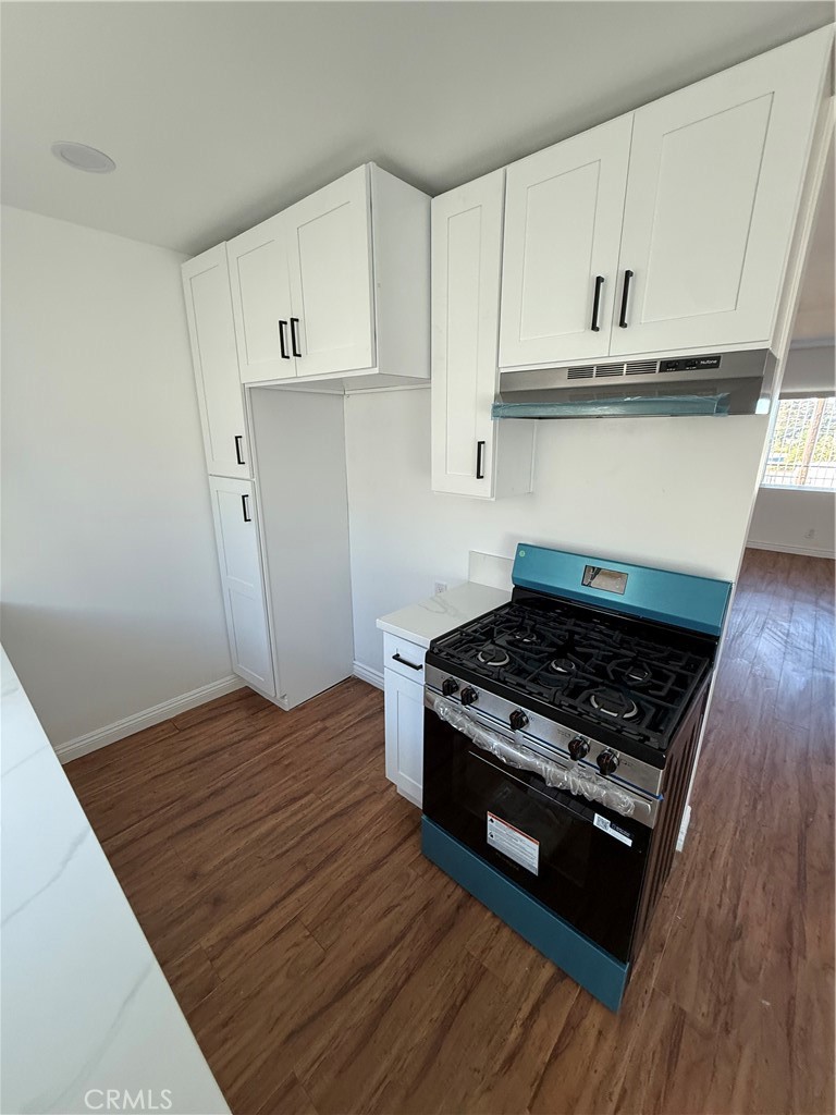 7159 Greeley Street, Unit F Tujunga, CA 91042 - Photo 6 of 15 a kitchen with wooden floors and appliances