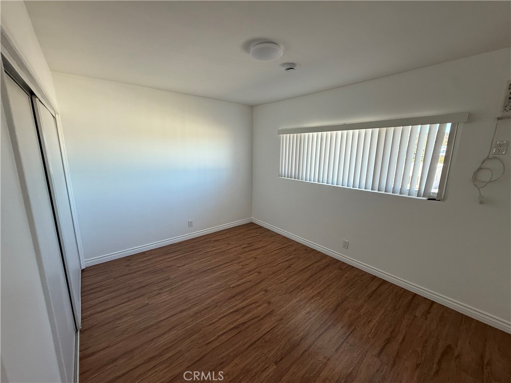 7159 Greeley Street, Unit F Tujunga, CA 91042 - Photo 7 of 15 an empty room with wooden floor and windows