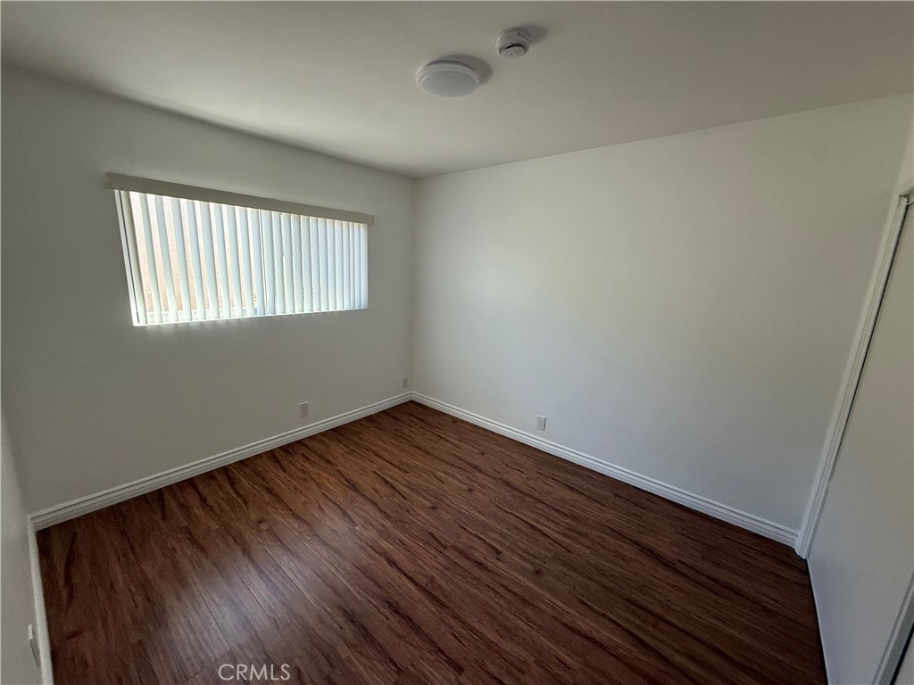 7159 Greeley Street, Unit F Tujunga, CA 91042 - Photo 8 of 15 an empty room with wooden floor and windows