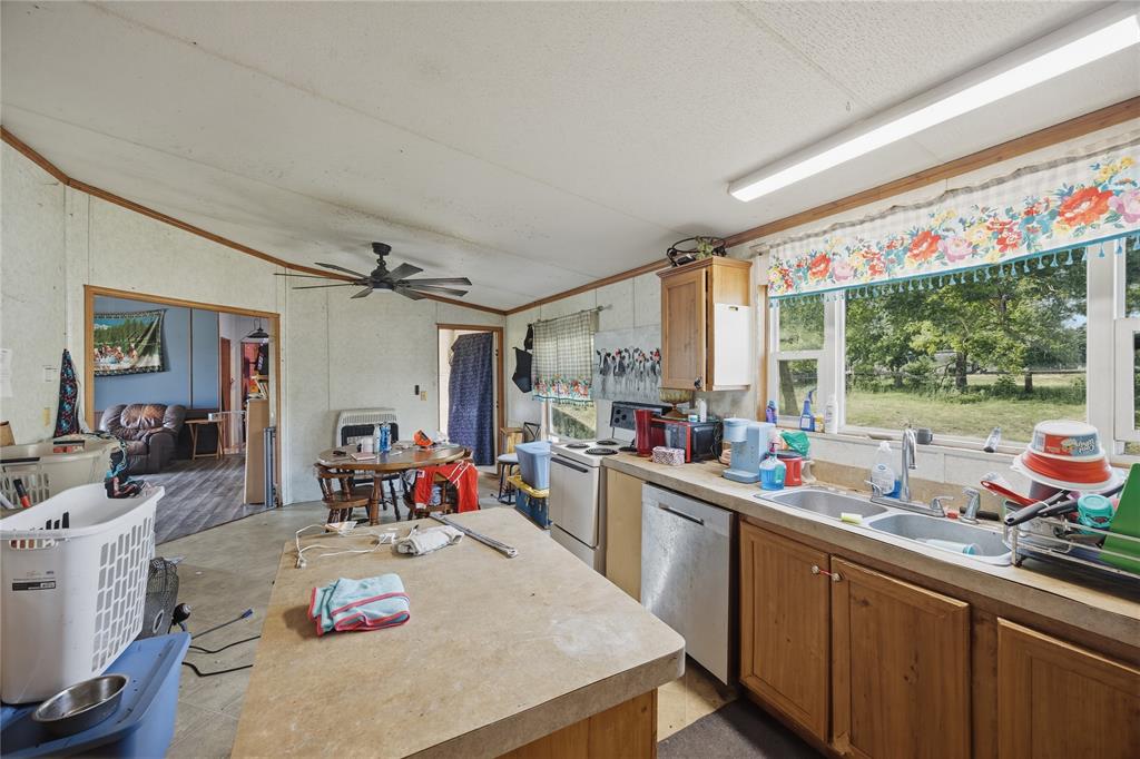 2449 East Fm 120 Denison, TX 75021 - Photo 23 of 30 a kitchen with a sink stove and wooden cabinets