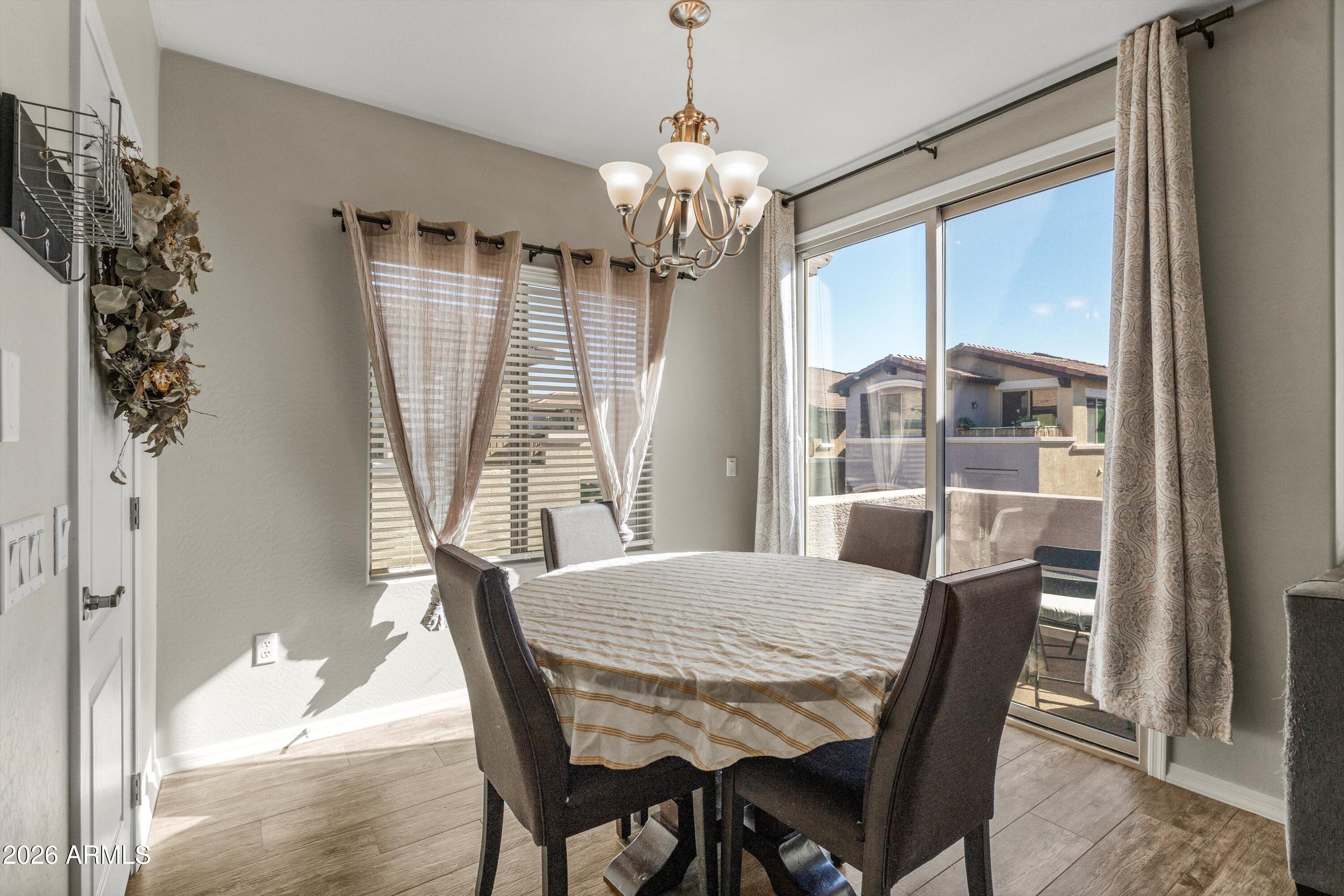 7726 East Baseline Road, Unit 247 Mesa, AZ 85209 - Photo 12 of 29 a view of a dining room with furniture window and wooden floor