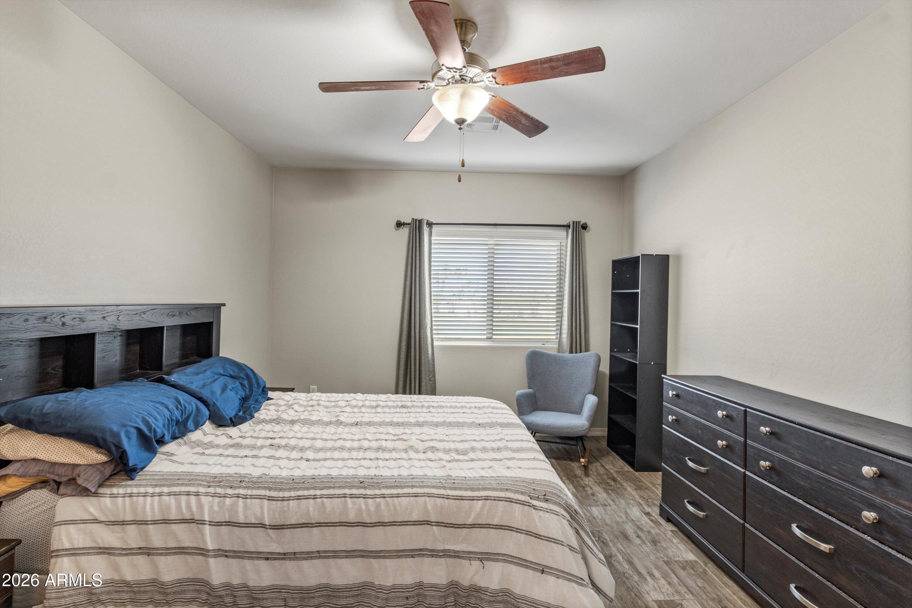 7726 East Baseline Road, Unit 247 Mesa, AZ 85209 - Photo 14 of 29 a bedroom with a bed and a chandelier