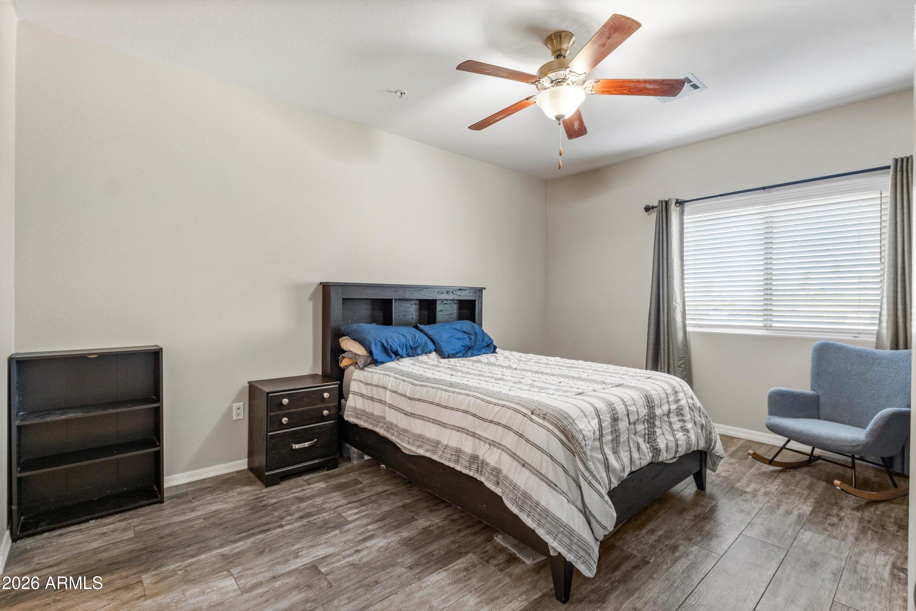 7726 East Baseline Road, Unit 247 Mesa, AZ 85209 - Photo 16 of 29 a bedroom with a bed and a ceiling fan