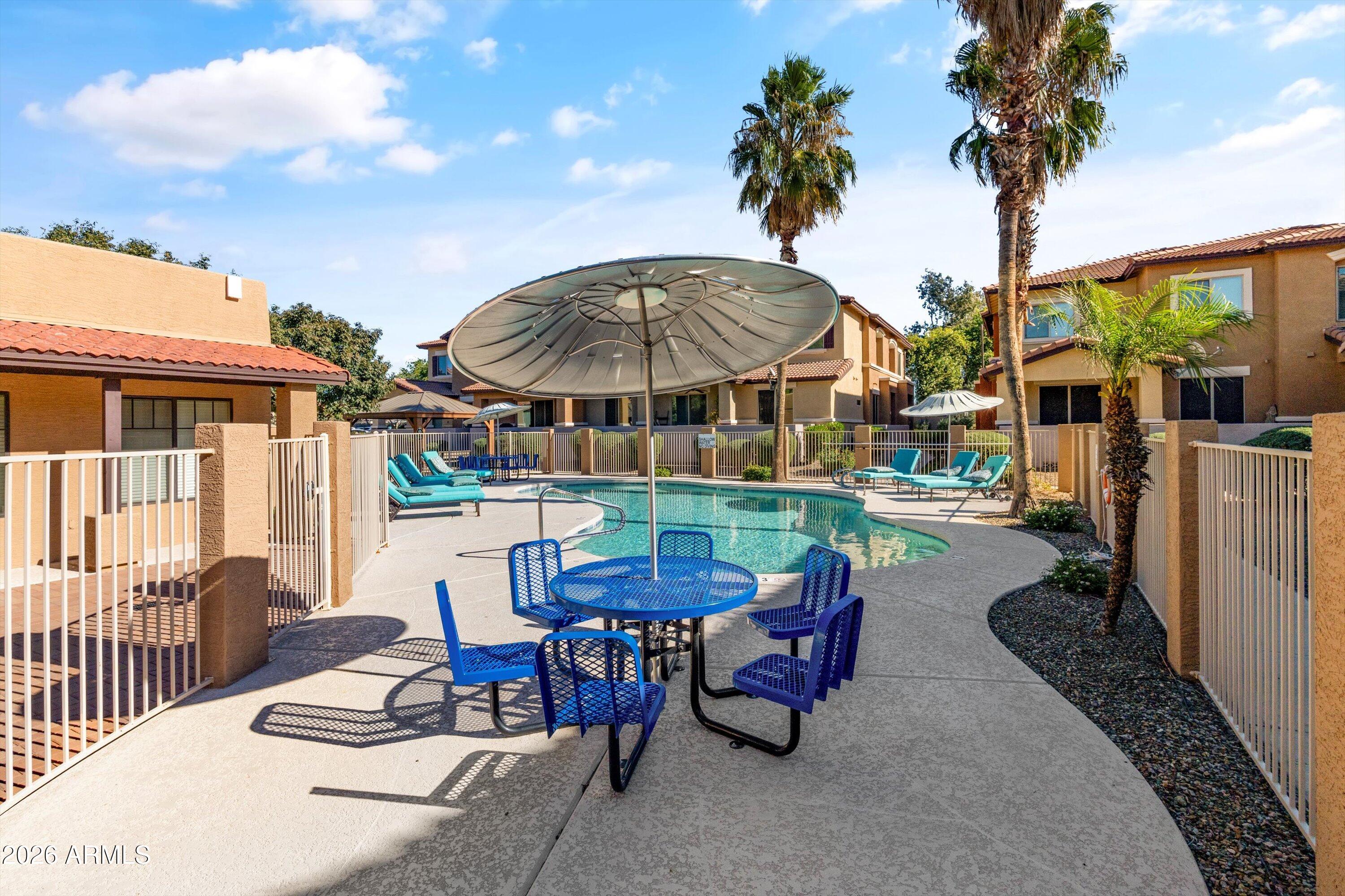 7726 East Baseline Road, Unit 247 Mesa, AZ 85209 - Photo 25 of 29 a view of a patio with a table chairs and a fire pit