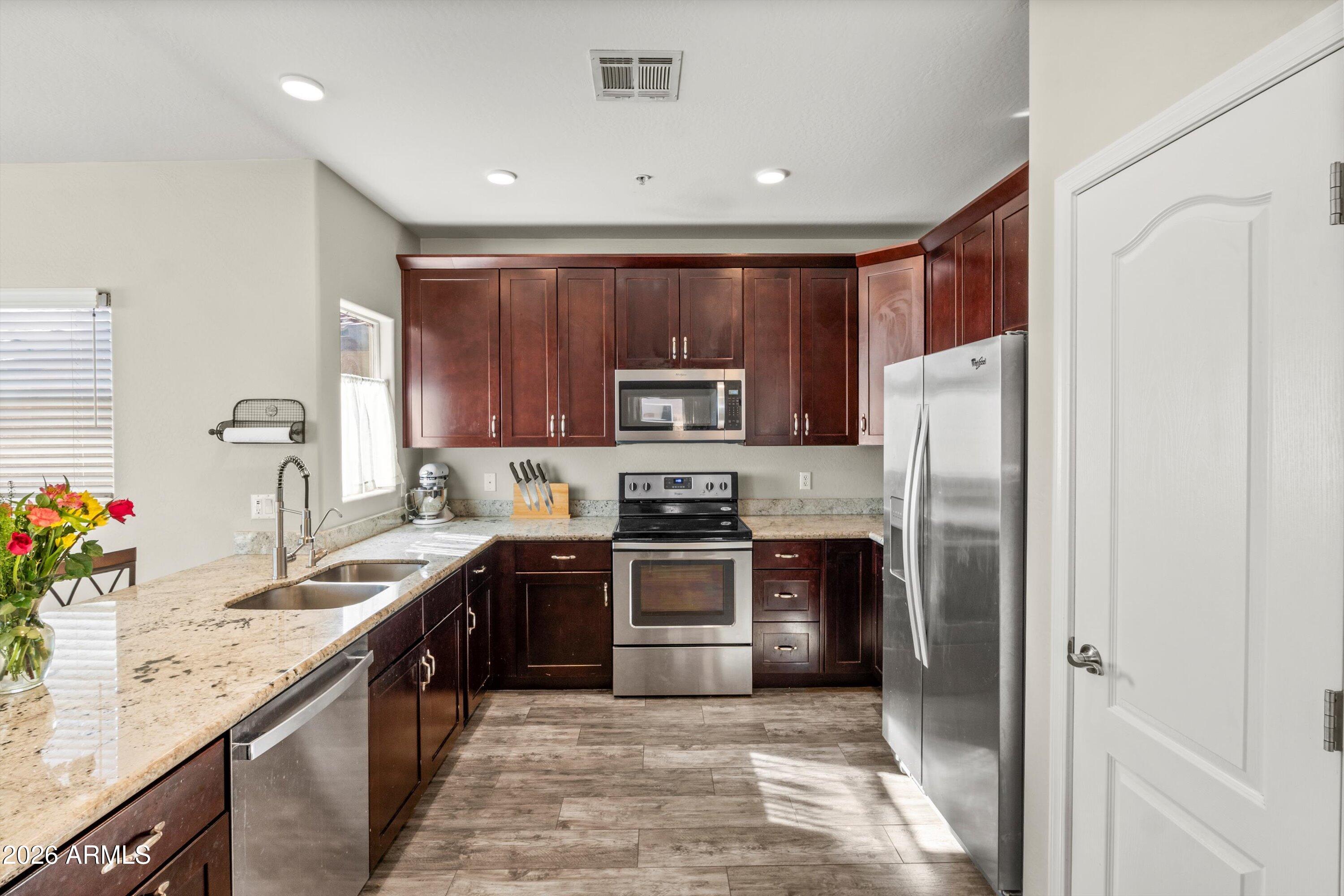7726 East Baseline Road, Unit 247 Mesa, AZ 85209 - Photo 6 of 29 a kitchen with stainless steel appliances granite countertop a refrigerator sink and stove