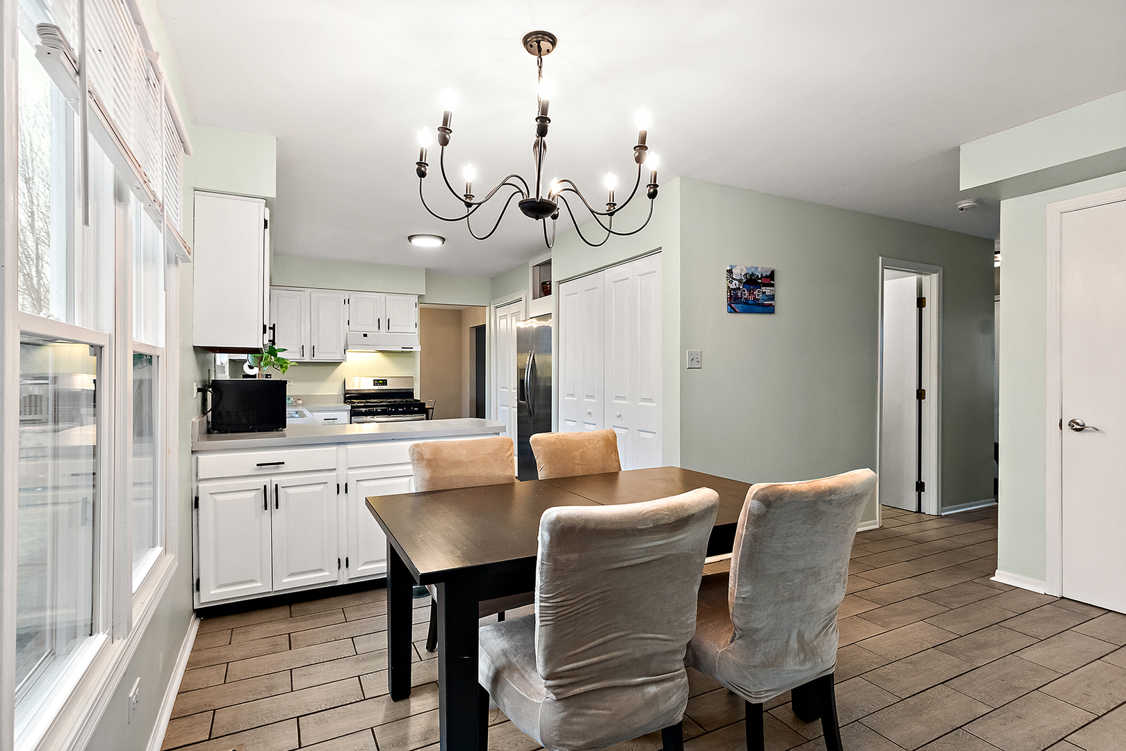 1813 Newport Road Downers Grove, IL 60516 - Photo 7 of 23 a kitchen with stainless steel appliances a table chairs and a chandelier
