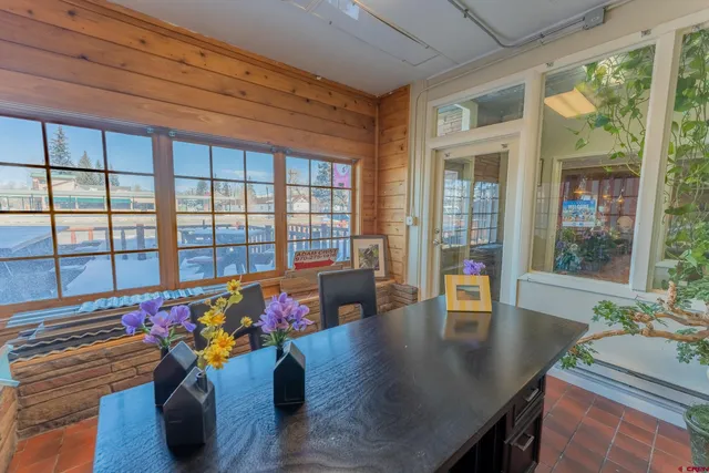 a view of a patio with table and chairs with wooden floor and fence
