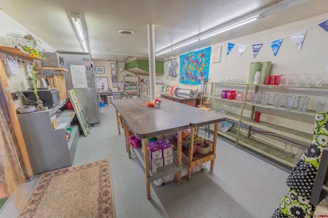 a living room with furniture and a refrigerator