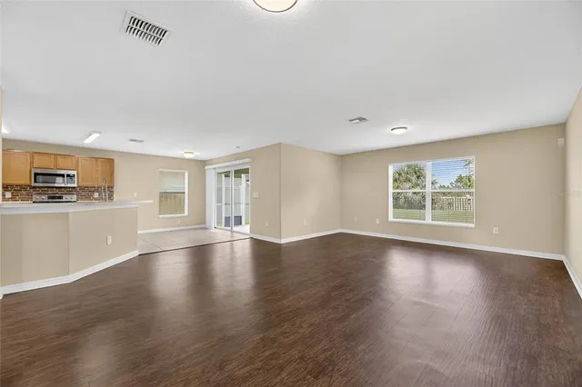 a view of empty room with wooden floor