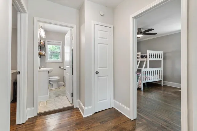 a view of a hallway with wooden floor and a bedroom