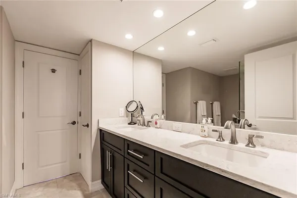 a bathroom with double vanity sinks and a mirror