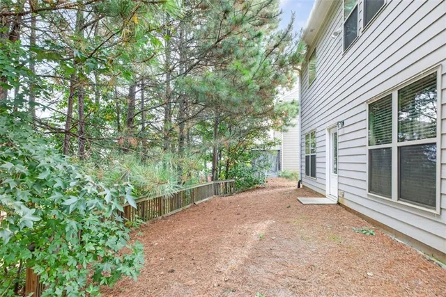 a view of a backyard with potted plants and large tree