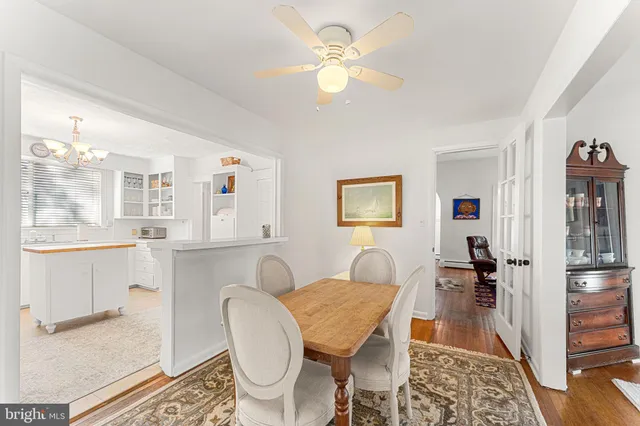 a dining room with wooden floor and a chandelier