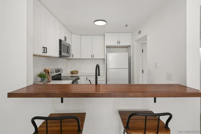 a kitchen with stainless steel appliances granite countertop a sink and a refrigerator