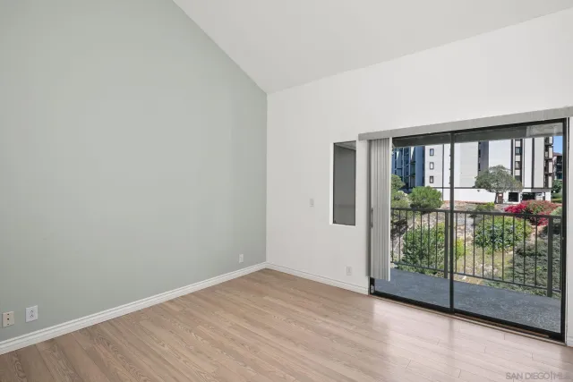 an empty room with sliding door and balcony