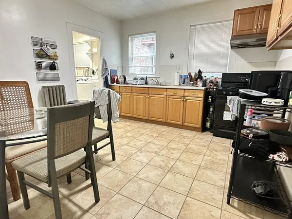 a kitchen with a sink a stove a dining table and chairs