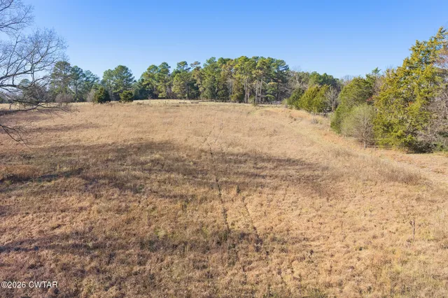 a kitchen with stainless steel appliances kitchen island granite countertop a refrigerator a stove and a dining table with wooden floor