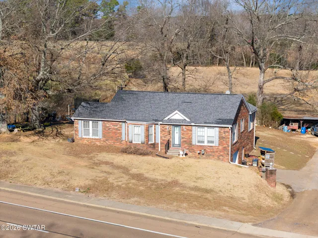 a view of a house with a yard and sitting area