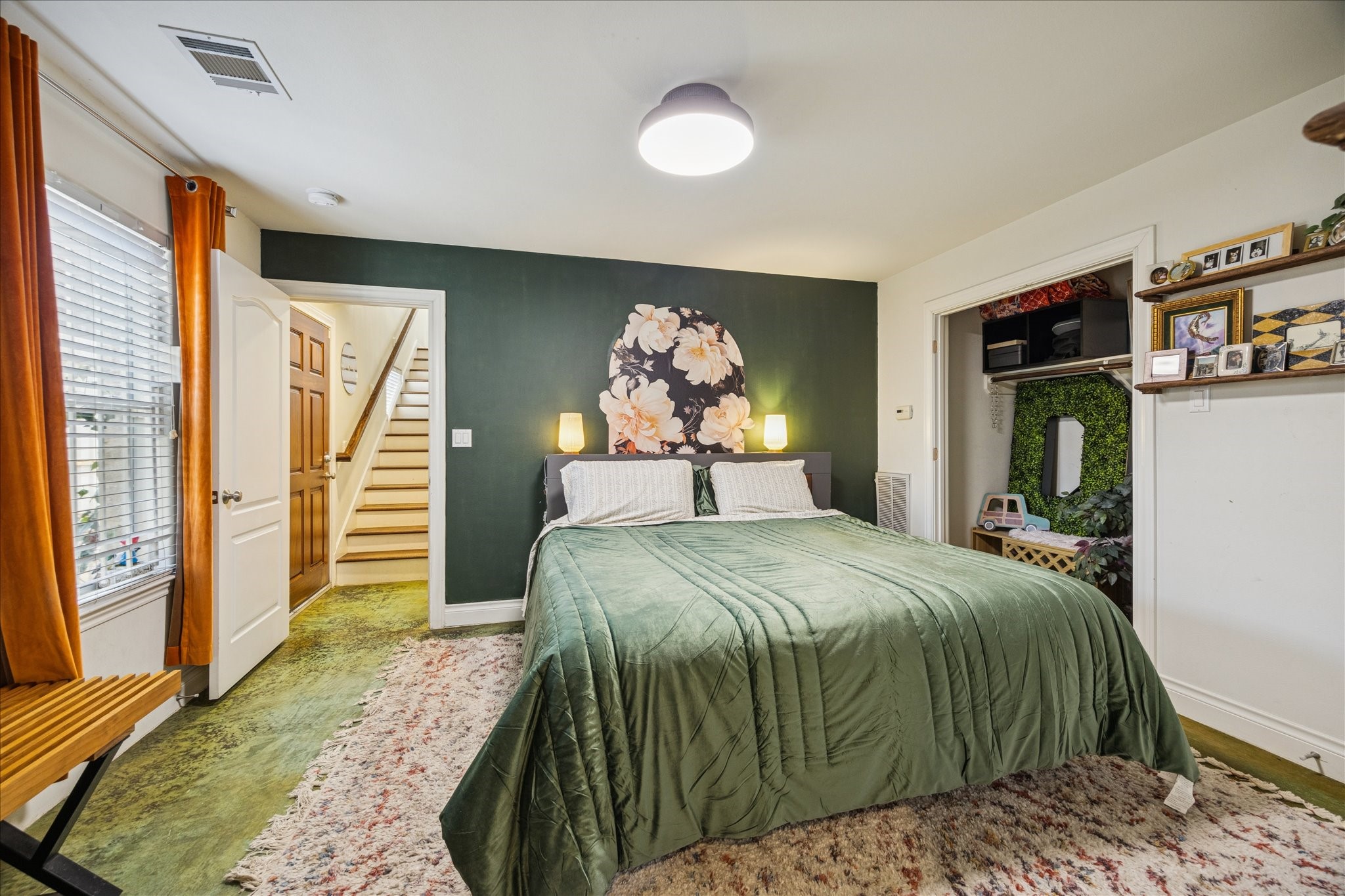 2207 Austin Street Houston, TX 77002 - Photo 12 of 34 And a look of the first floor bedroom from the bathroom door. The wood door at the bottom of the stairs leads out to the fenced backyard. Stained concrete flooring keeps it nice and cool during the summer months.