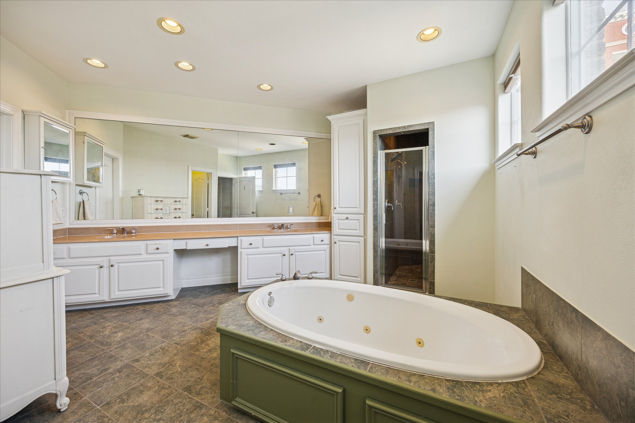 2207 Austin Street Houston, TX 77002 - Photo 18 of 34 Now to the 3rd floor primary bathroom! Wow! Jetted huge tub, double sinks, large vanity, windows, huge walk-in closet to the back left and walk-in shower ahead.