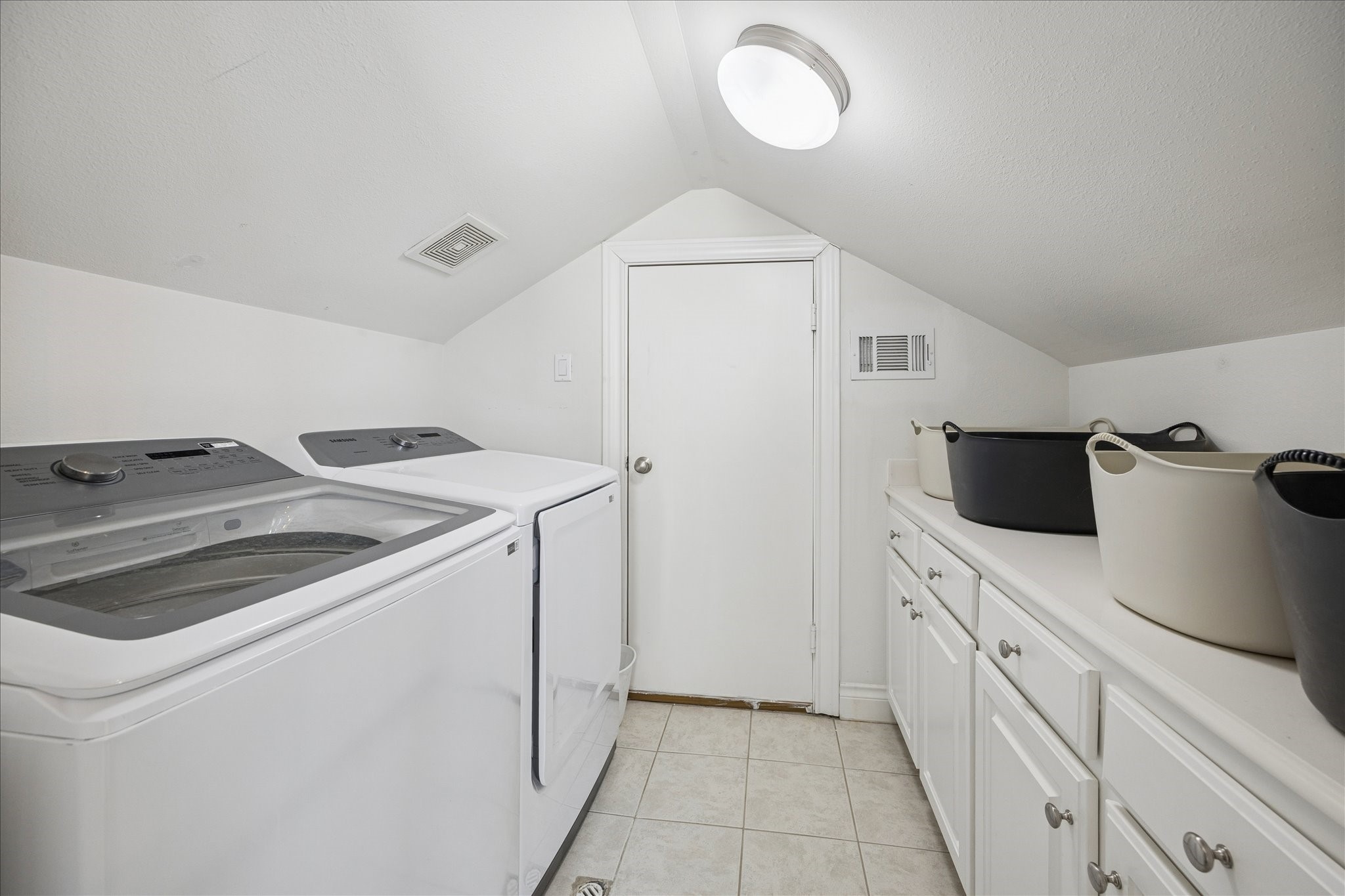 2207 Austin Street Houston, TX 77002 - Photo 25 of 34 The utility room is on the 4th floor, and it too has a lot of storage and great countertop! The door ahead leads to the attic aned more storage. The washer and dryer are 2 years old and will stay with the home.