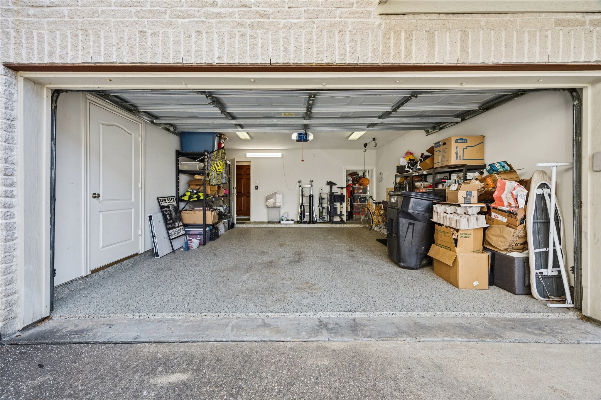 2207 Austin Street Houston, TX 77002 - Photo 28 of 34 And look at this! A huge 2 car garage with epoxy flooring. The wooden door straight ahead through the house leads to the backyard area. To open door just past the bicycle is a huge storage room.