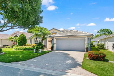 a front view of a house with a garden and yard