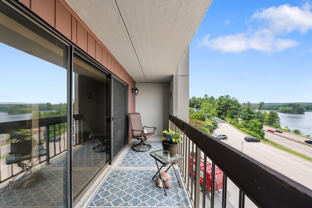 1500 Worcester Road, Unit 624 Framingham, MA 01702 - Photo 16 of 26 a balcony with wooden floor and outdoor seating