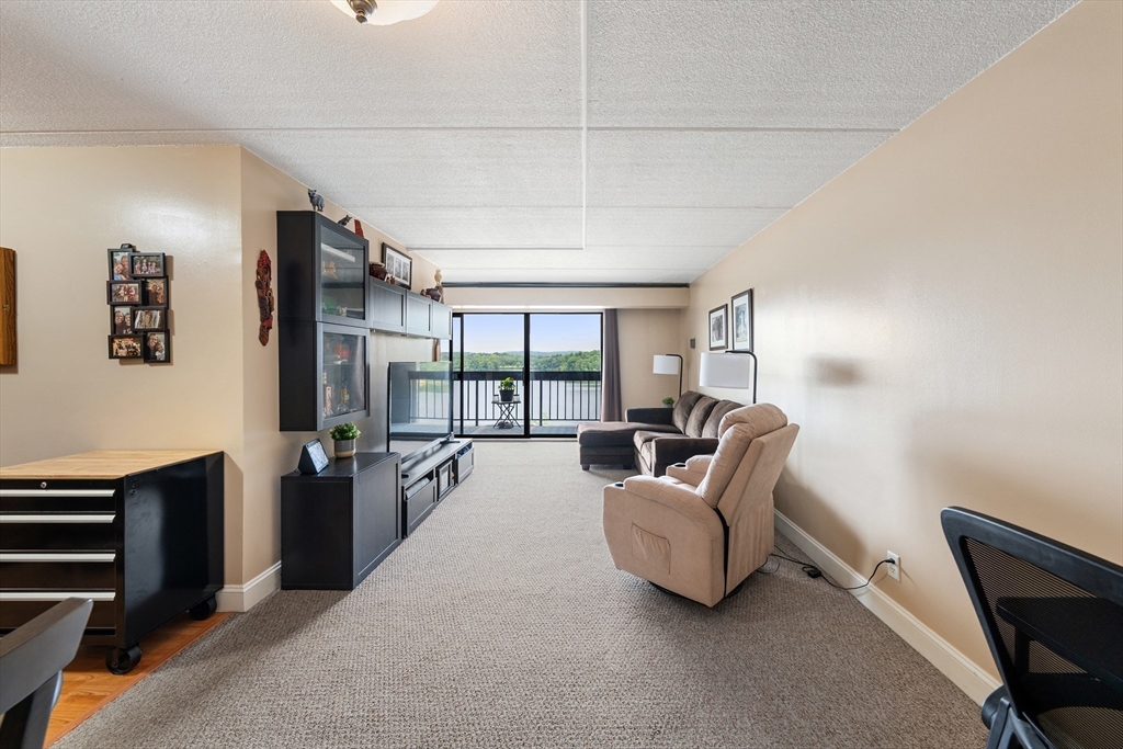 1500 Worcester Road, Unit 624 Framingham, MA 01702 - Photo 5 of 26 a living room with furniture a large window and stainless steel appliances