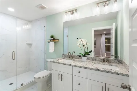 a bathroom with a granite countertop sink toilet and shower