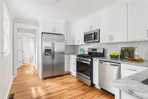 a kitchen with stainless steel appliances granite countertop a refrigerator stove and sink