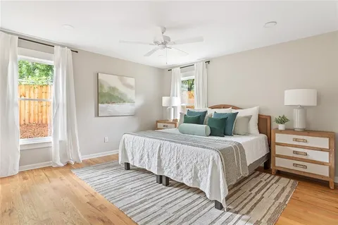 a bedroom with a large bed a chandelier and windows
