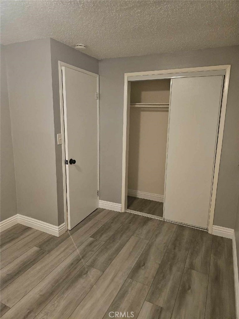 a view of an empty room with closet and a window