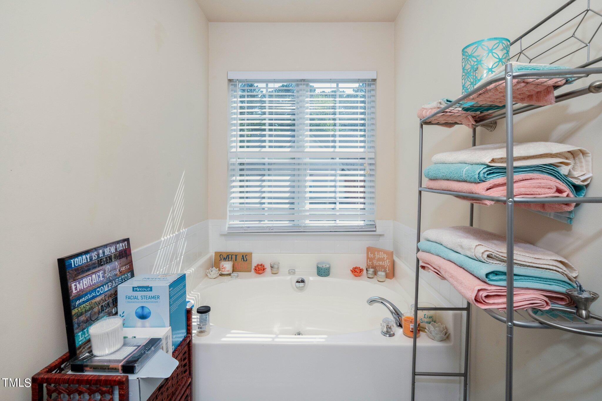 9828 Layla Avenue Raleigh, NC 27617 - Photo 14 of 21 a bathroom with a bathtub a sink and a window