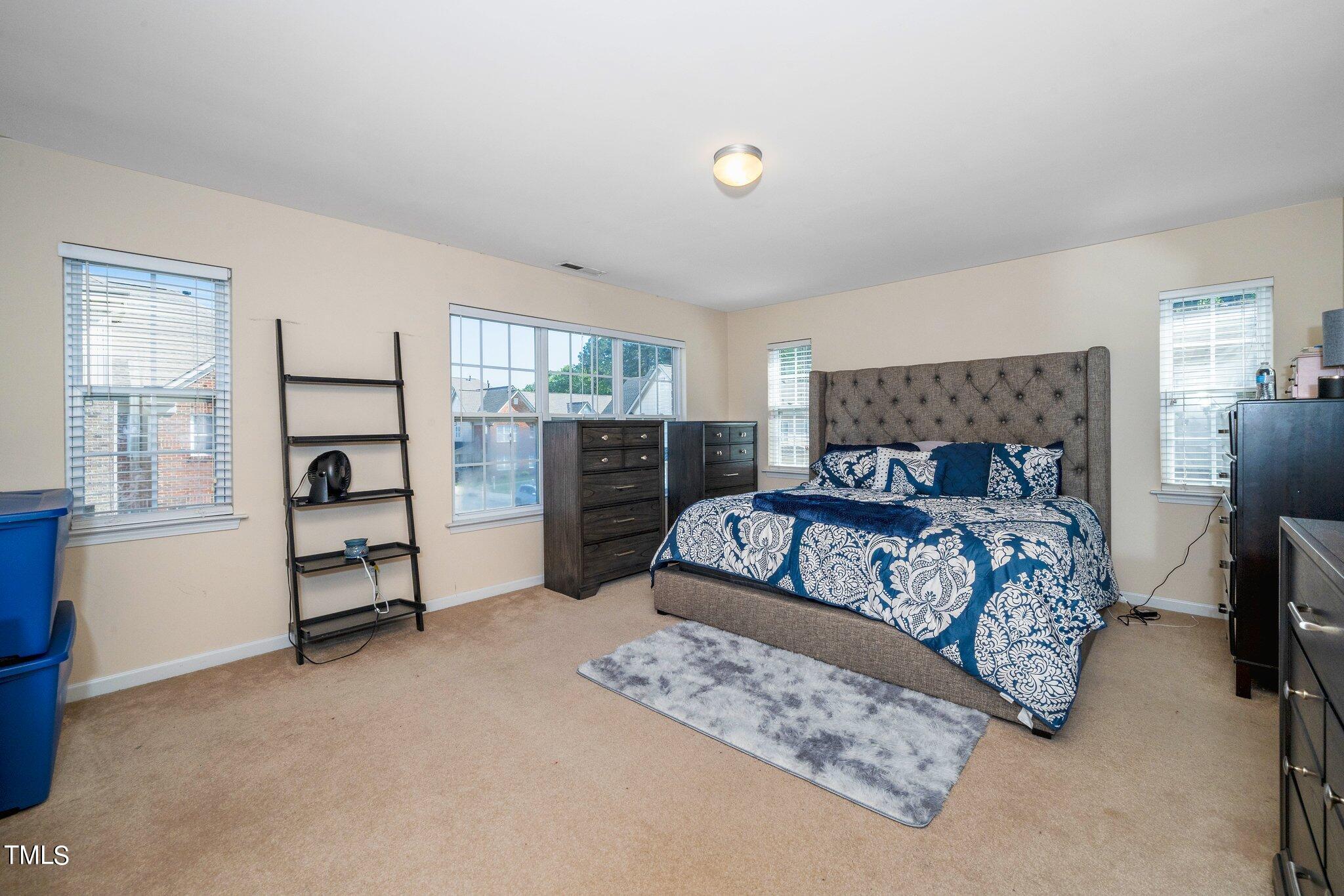9828 Layla Avenue Raleigh, NC 27617 - Photo 15 of 21 a bedroom with a bed and wooden floor