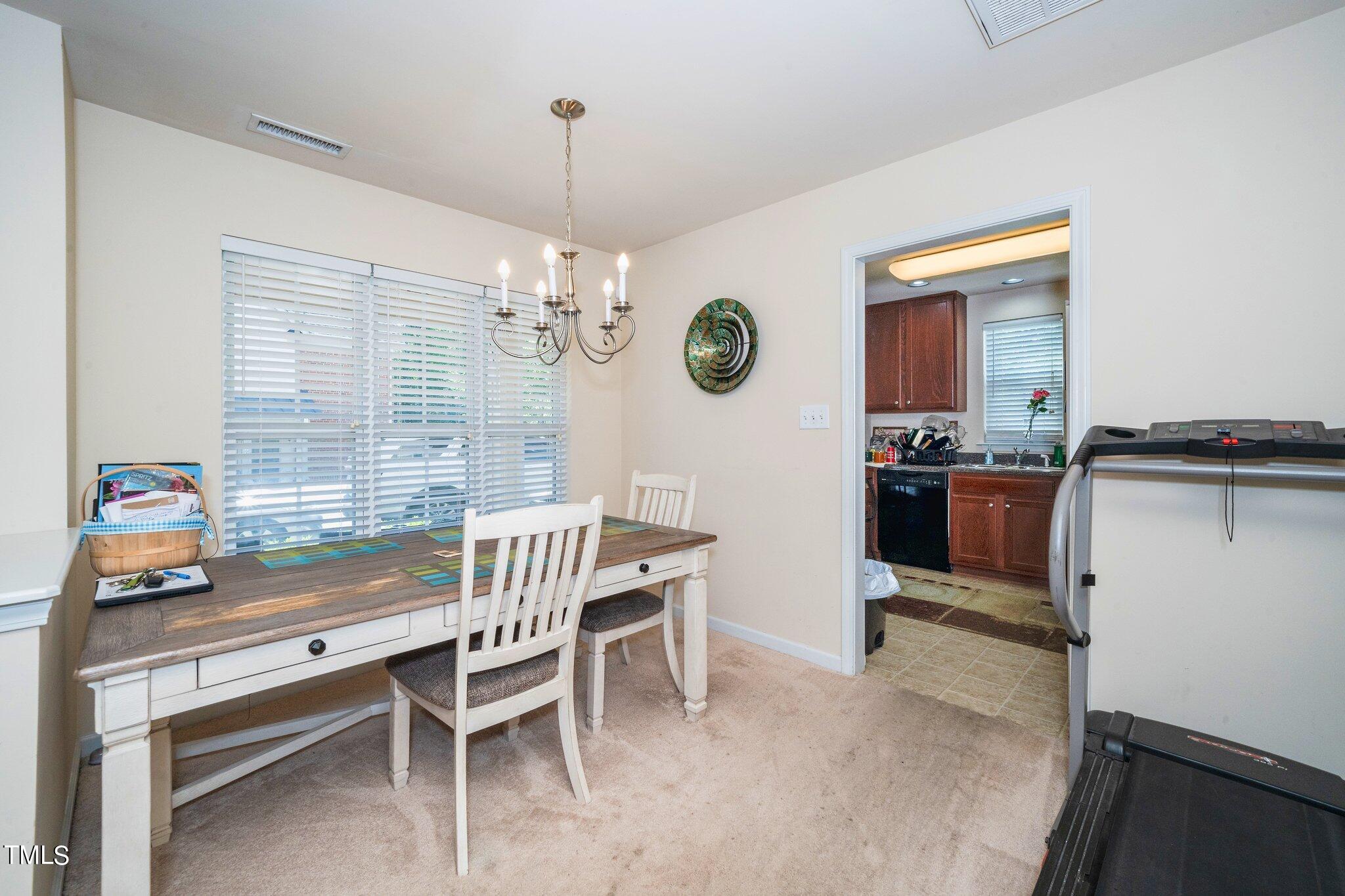 9828 Layla Avenue Raleigh, NC 27617 - Photo 7 of 21 a view of a dining room and chandelier