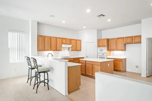 a kitchen with a table chairs stove and cabinets