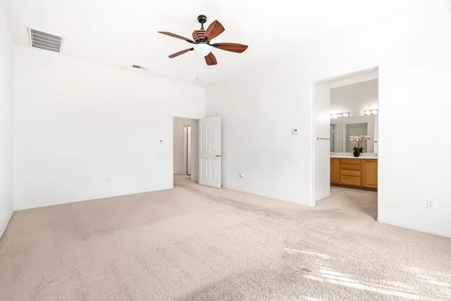 a view of a room with a ceiling fan and window