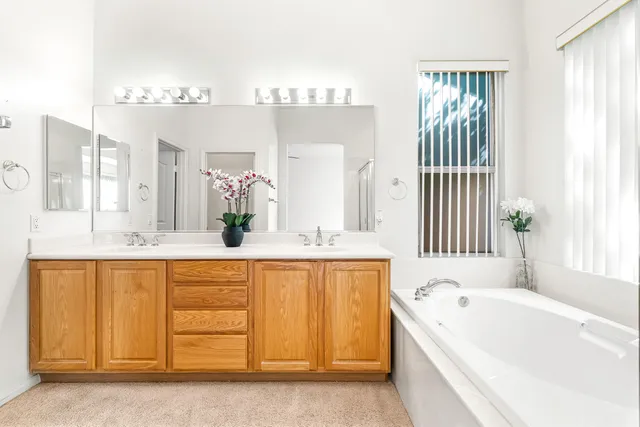 a bathroom with a bathtub a sink and a large mirror